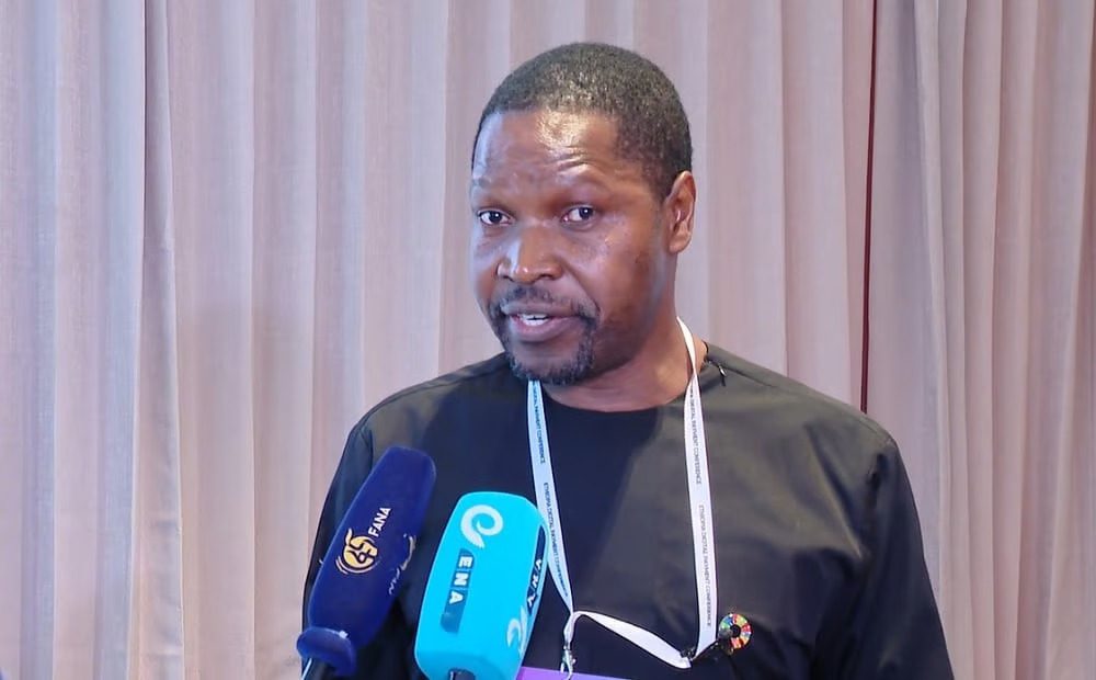 A man speaking at a press conference about Africa’s transition toward an integrated digital economy, featuring FANA and ENA news microphones.